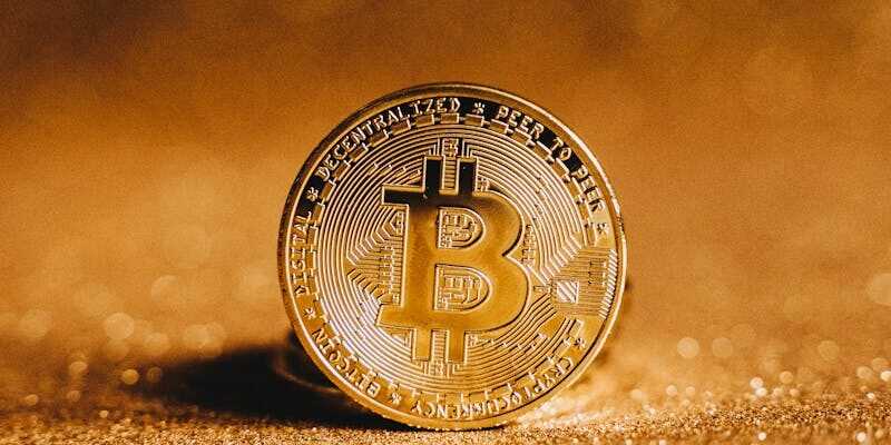 Close-up of a golden Bitcoin with a sparkling background, symbolizing digital finance.