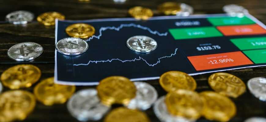 Bitcoin and altcoins on table with digital trading chart indicating market trends and investment details.