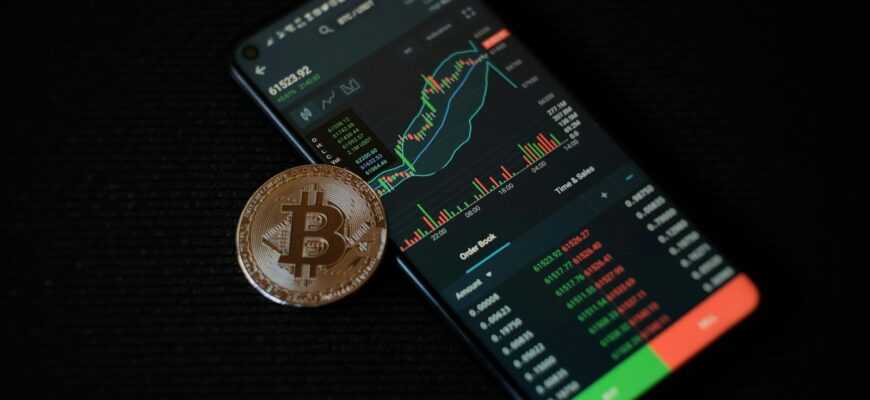 a bitcoin sitting on top of a smart phone