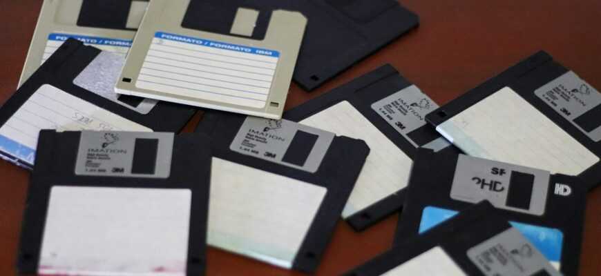 A pile of floppy disk drives sitting on top of a table