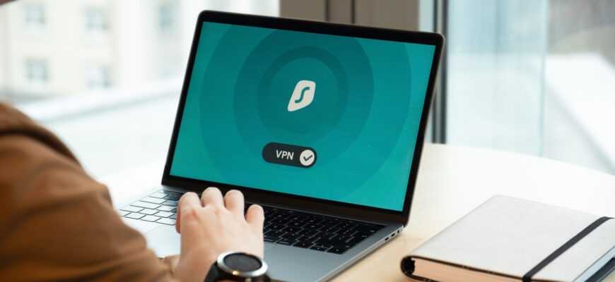 person using macbook pro on white table