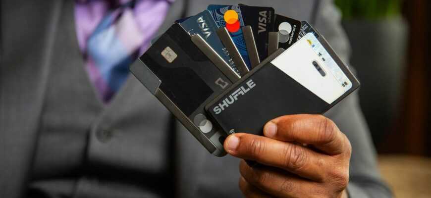a man in a suit holding four credit cards