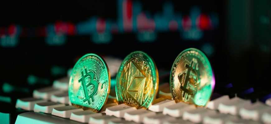 Cryptocurrency coins sit on a keyboard.