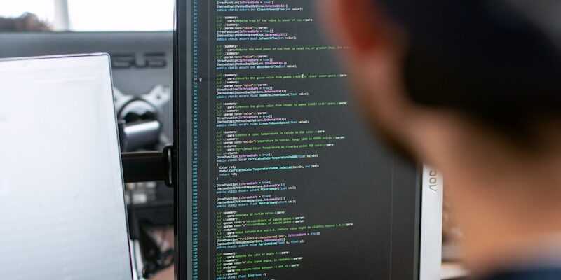 man in black shirt sitting in front of computer monitor