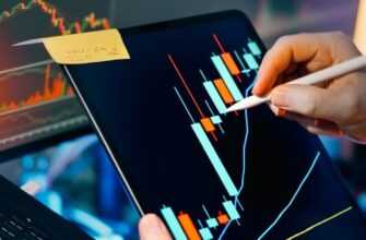 Trader analyzing stock market charts on tablet and monitor
