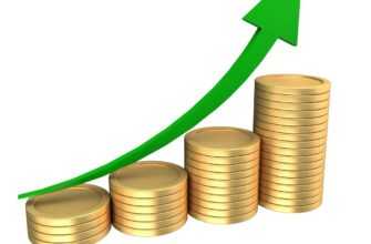 Stacks of coins with an upward trending green arrow