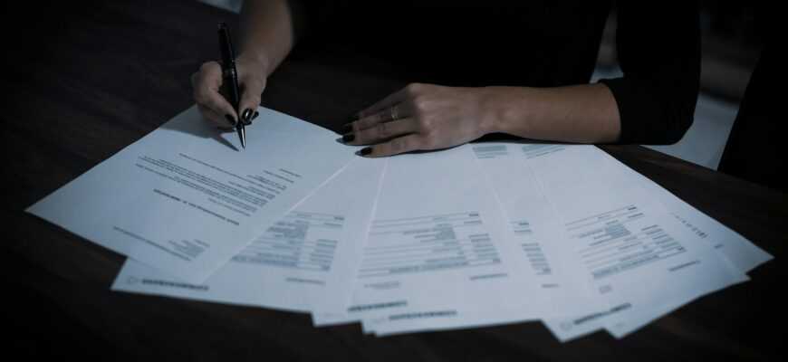 a woman sitting at a table with lots of papers